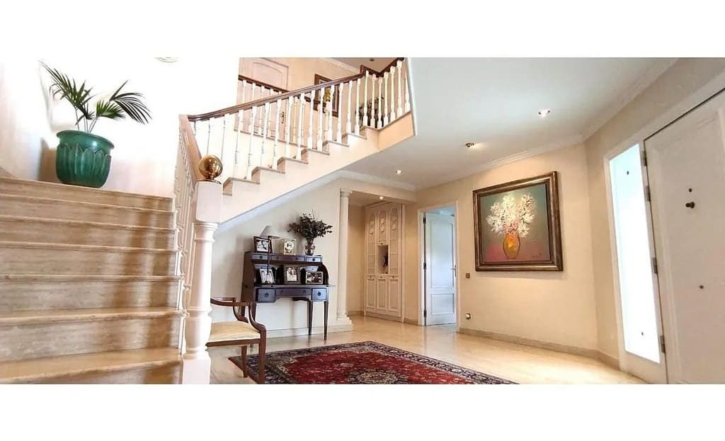 Холл с лестницей и мраморными полами.