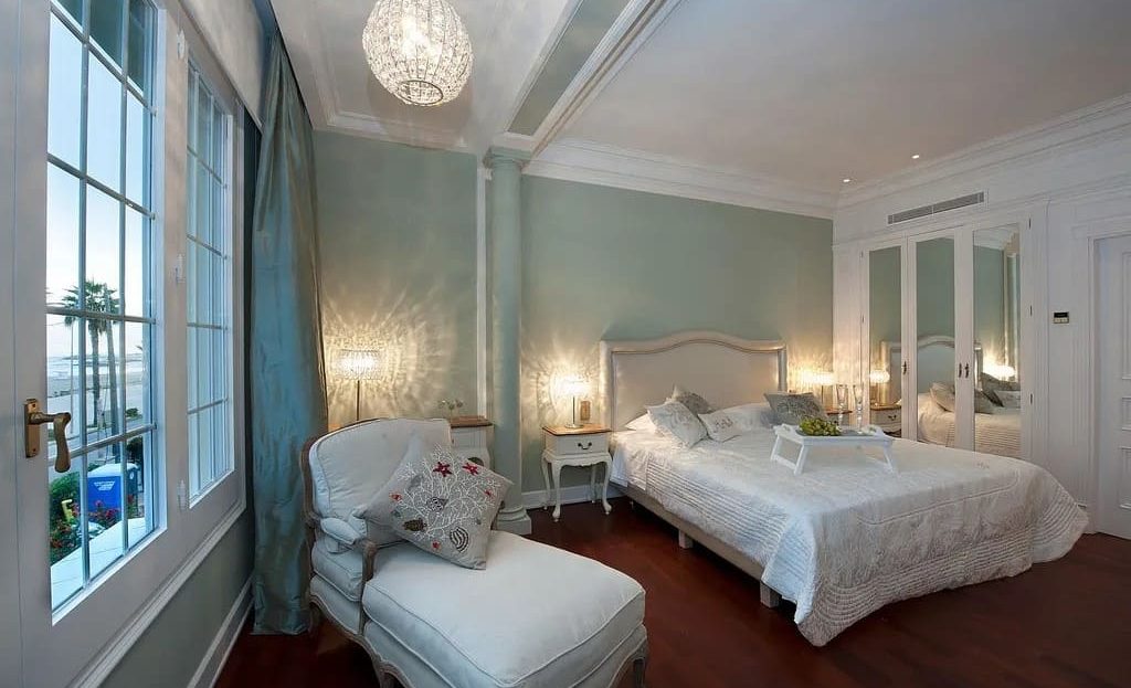 Элегантная спальня с классическим интерьером и большими окнами