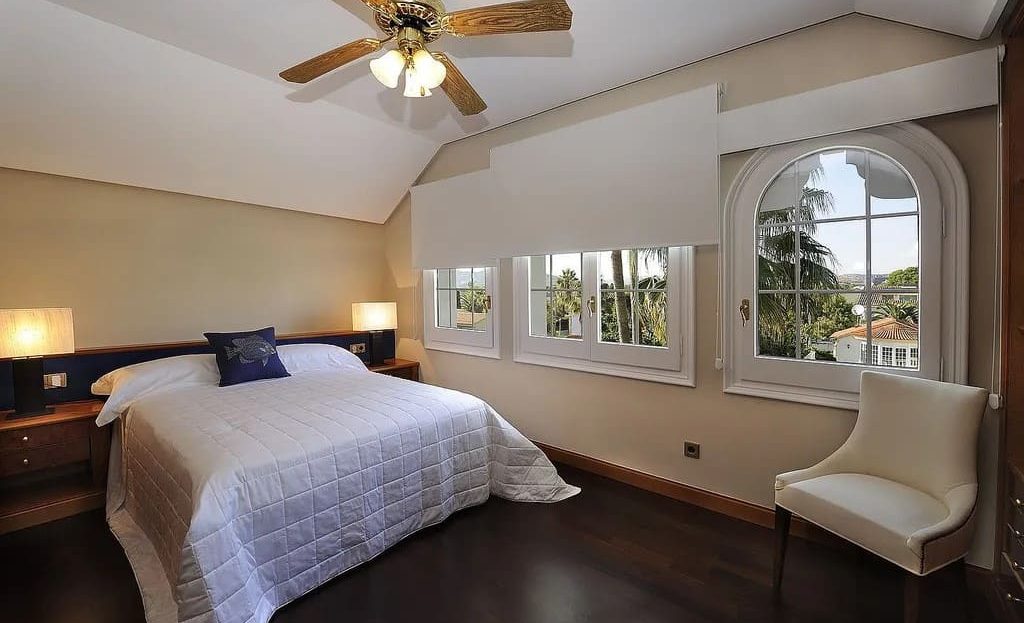 Просторная спальня с двуспальной кроватью и видом на сад