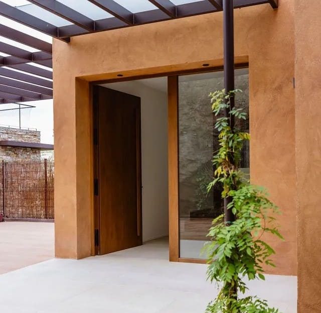 Главный вход в виллу с навесом и вертикальным озеленением.