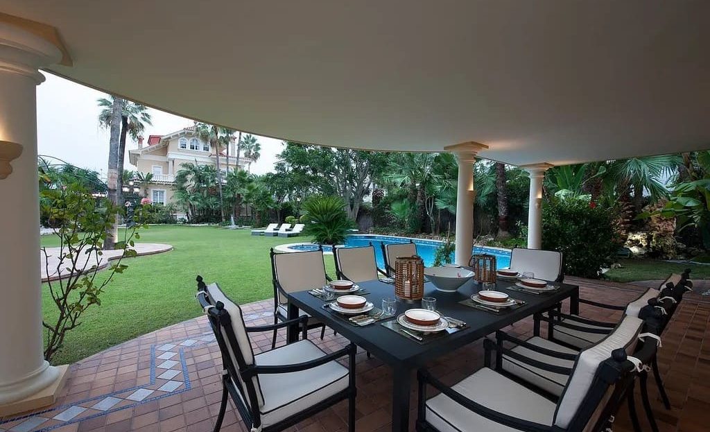 Крытая терраса с обеденной зоной и видом на сад