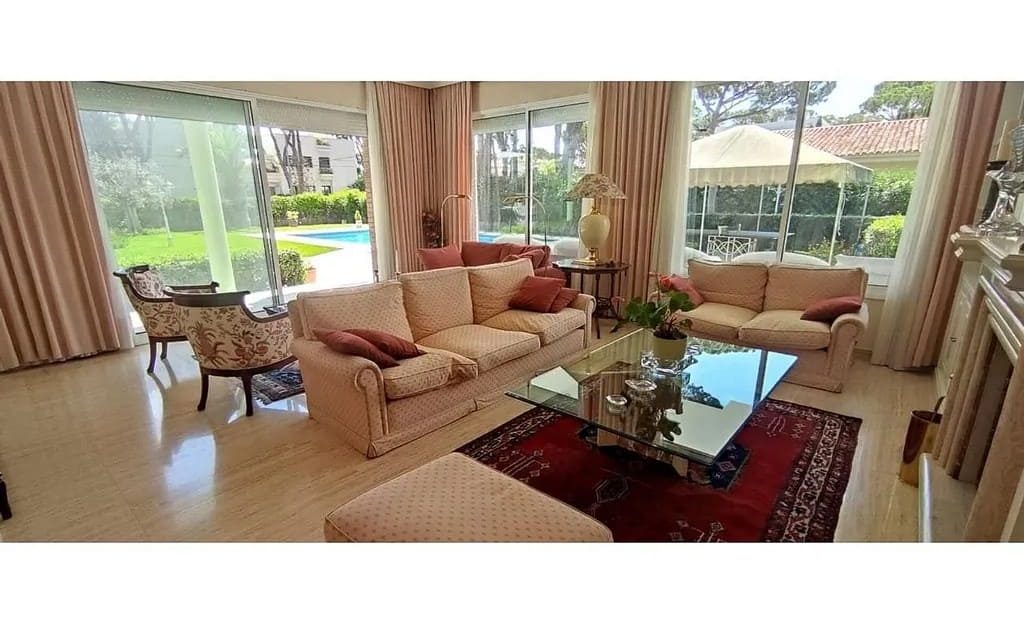 Гостиная с панорамными окнами и видом на сад.