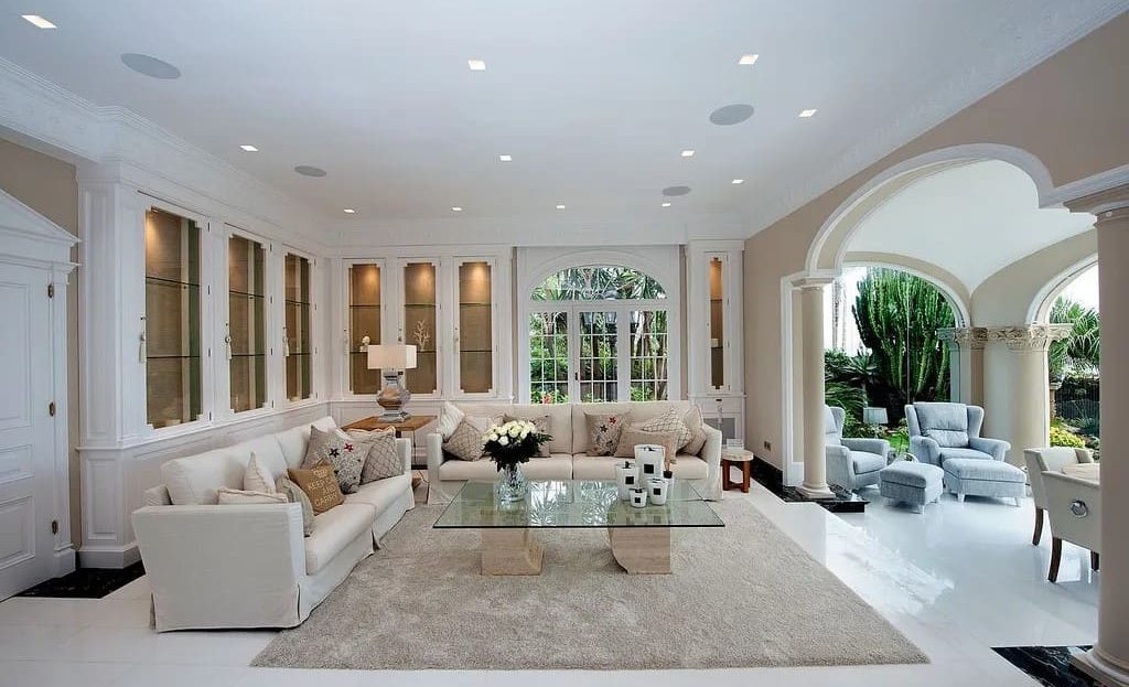 Просторная гостиная с панорамными окнами и выходом в сад