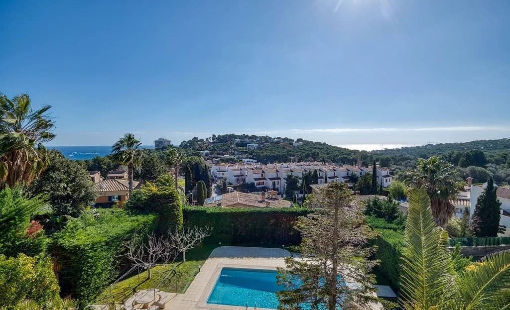 Панорамный вид на бассейн и сады виллы с видом на горы.