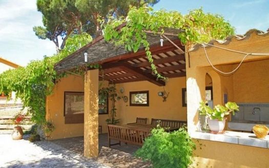 Фасад виллы с крыльцом и садом.