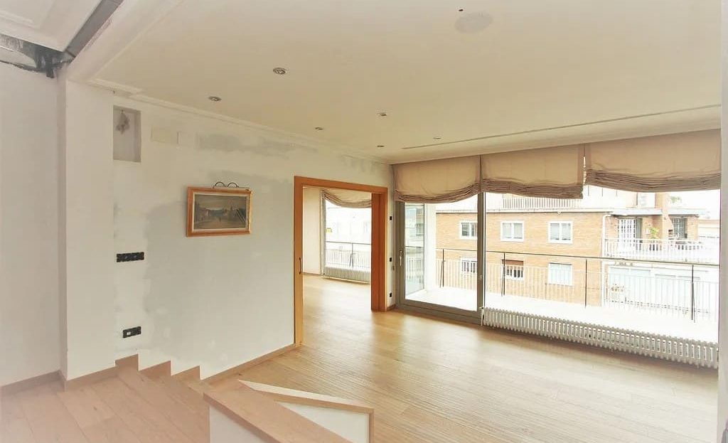 Просторная гостиная пентхауса с большими окнами и выходом на террасу