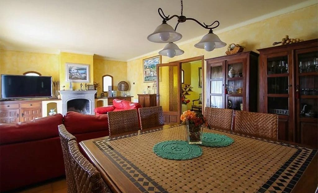 Гостиная-столовая с камином и выходом наружу.