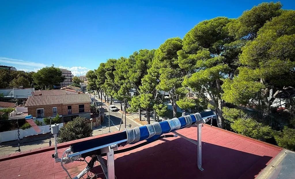 Вид с верхнего этажа дома на деревья и соседние постройки.