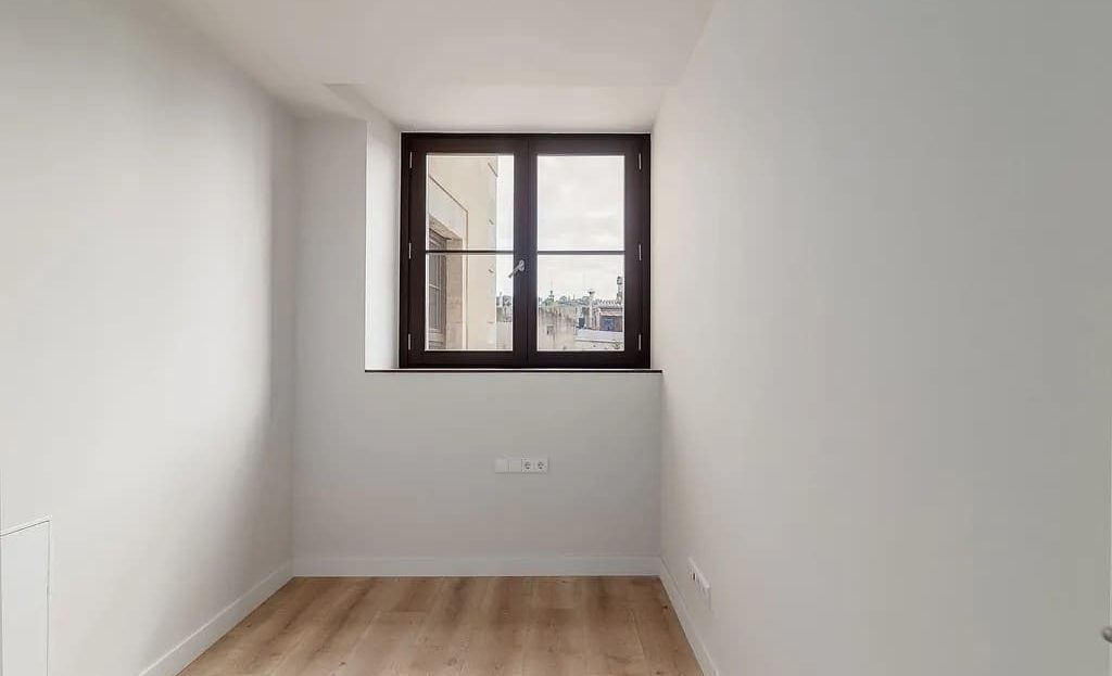 Небольшая комната с окном и минималистичной отделкой