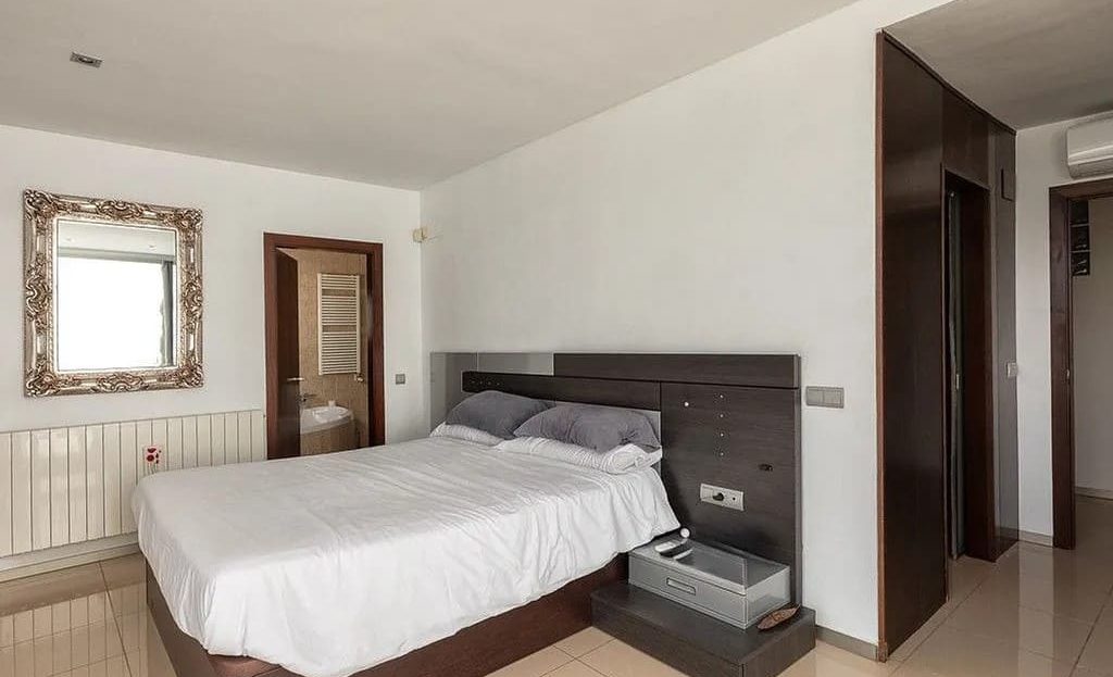 Спальня с двуспальной кроватью и встроенной мебелью