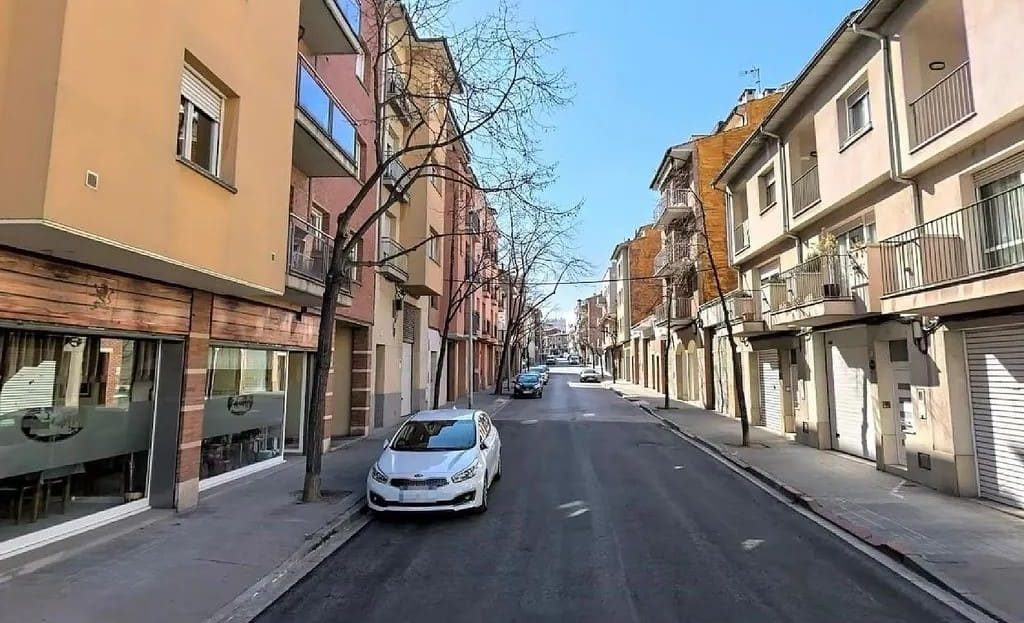 Улица с жилыми зданиями и припаркованным автомобилем.