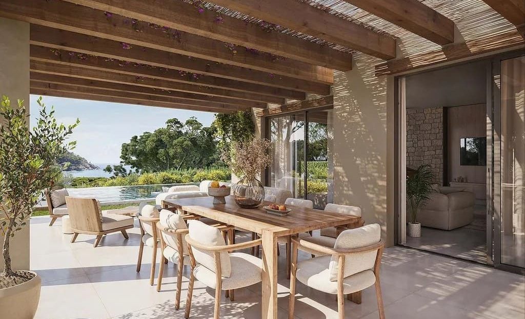 Просторная крытая терраса с обеденной зоной и видом на сад и бассейн.