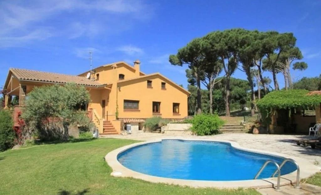 Бассейн и сад с видом на виллу.