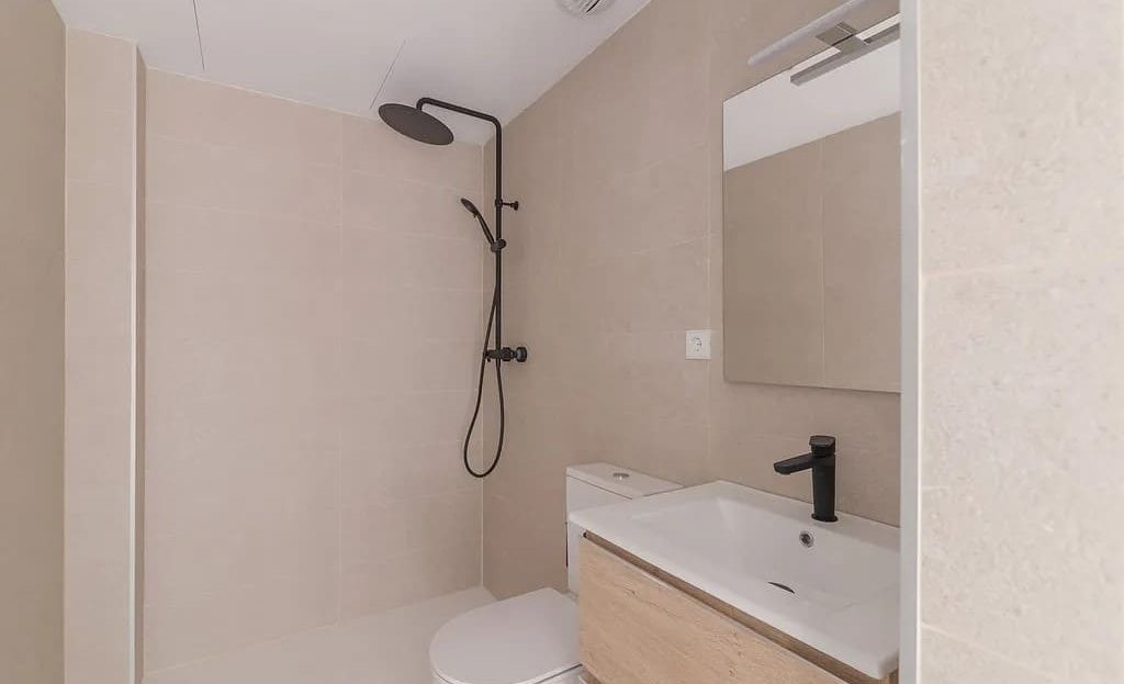 Современная ванная комната с душем и светлой отделкой