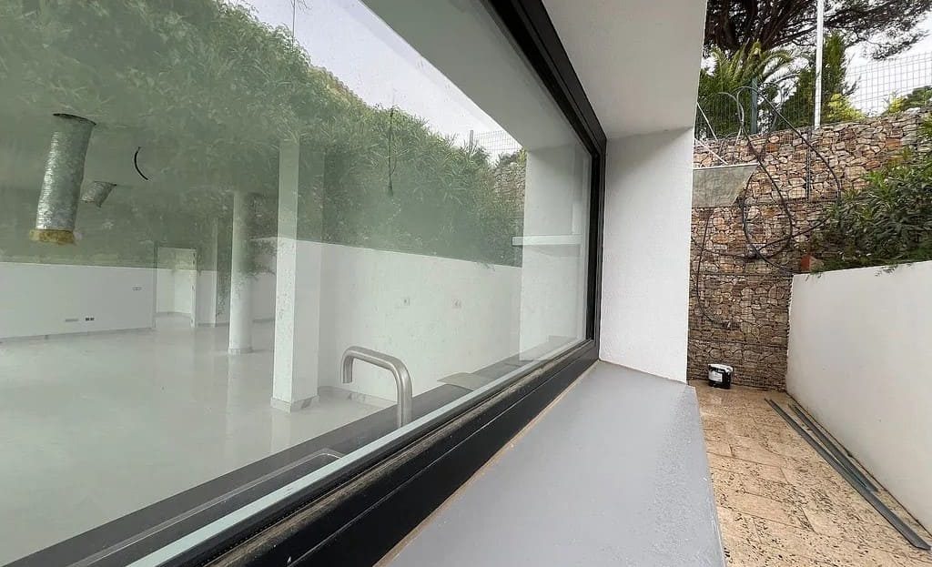 Панорамное окно с видом на сад у новой виллы