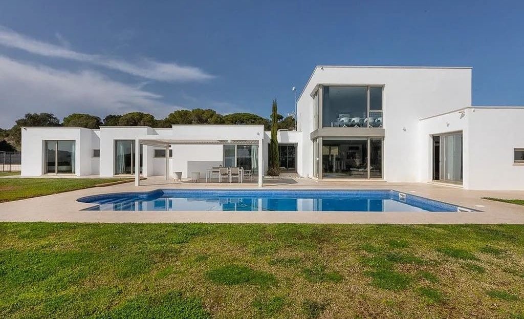 Фасад современной виллы с садом и бассейном