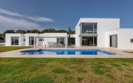 Фасад современной виллы с садом и бассейном