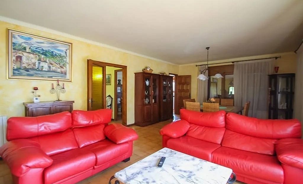 Гостиная с красной мягкой мебелью и телевизором.