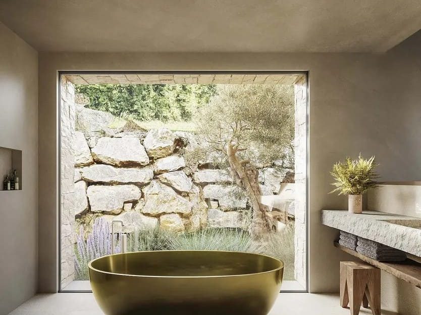 Ванная комната с дизайнерской ванной у окна с видом на природный каменный склон.