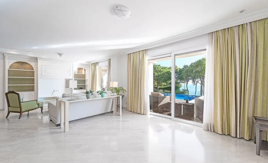 Просторная зона гостиной и столовой с большими окнами