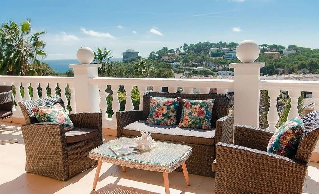 Солнечная терраса с мебелью и видом на холмы.