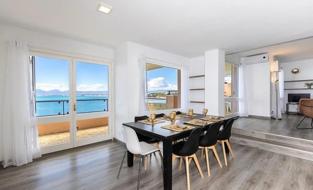 Столовая зона с панорамными окнами и видом на Средиземное море.