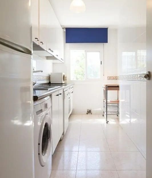 Кухня с окнами, техникой и отдельной рабочей зоной.