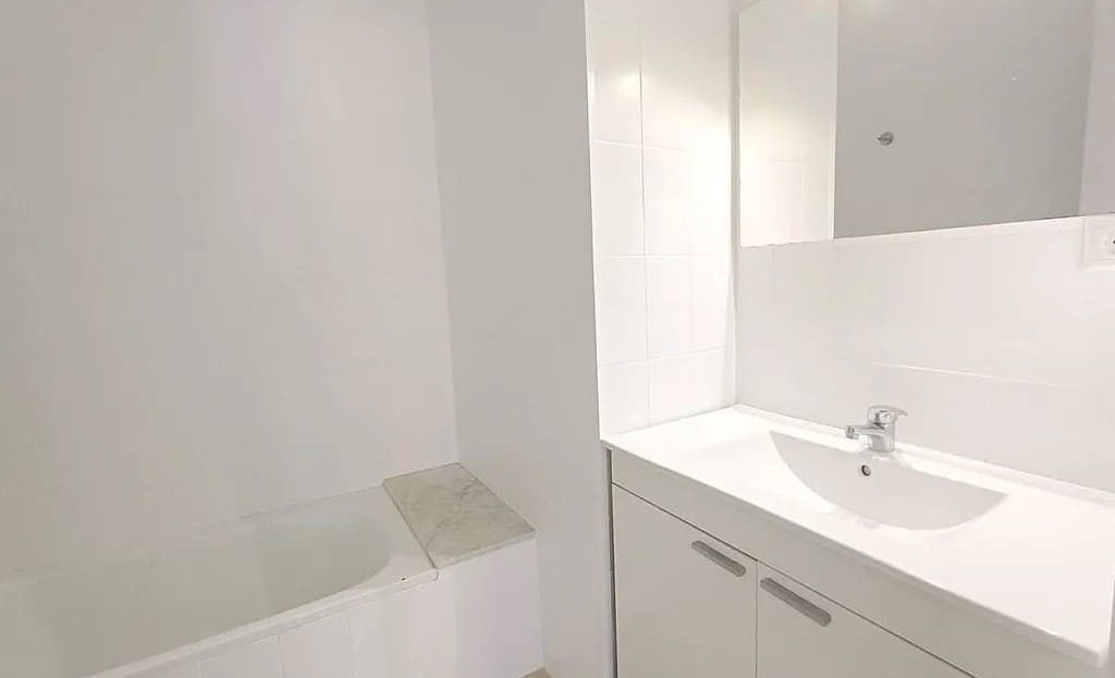 Ванная комната с ванной и раковиной в светлом оформлении.