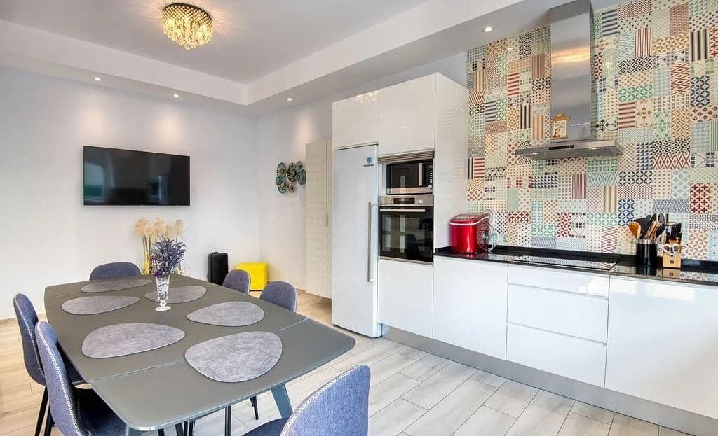 Современная кухня с обеденной зоной и декоративным фартуком