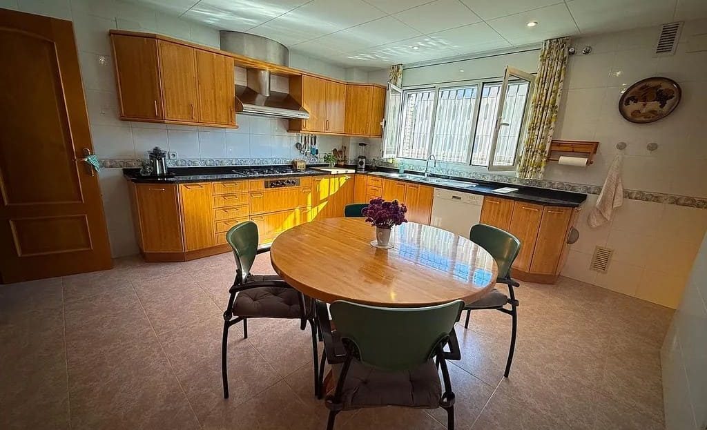 Просторная кухня с обеденной зоной и деревянной мебелью.