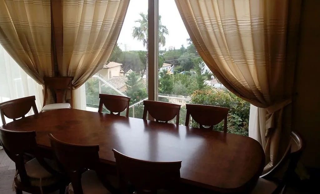 Столовая зона с деревянным столом и окнами