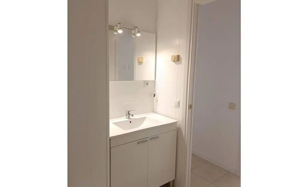 Умывальная зона ванной комнаты с раковиной и зеркалом.