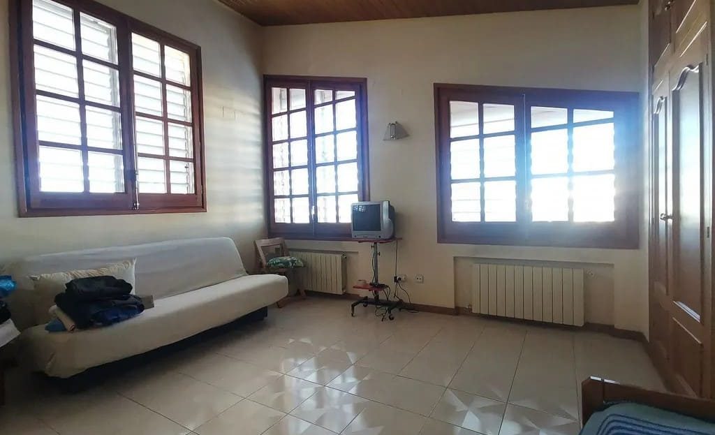 Комната с несколькими окнами, подходящая для кабинета или дополнительной спальни.