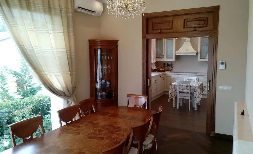 Столовая, соединённая с кухней, с видом на сад