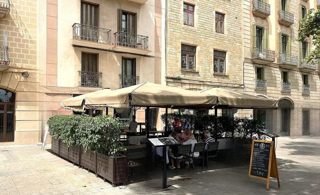 Фасад коммерческого помещения в Готическом квартале Барселоны с открытой террасой ресторана.