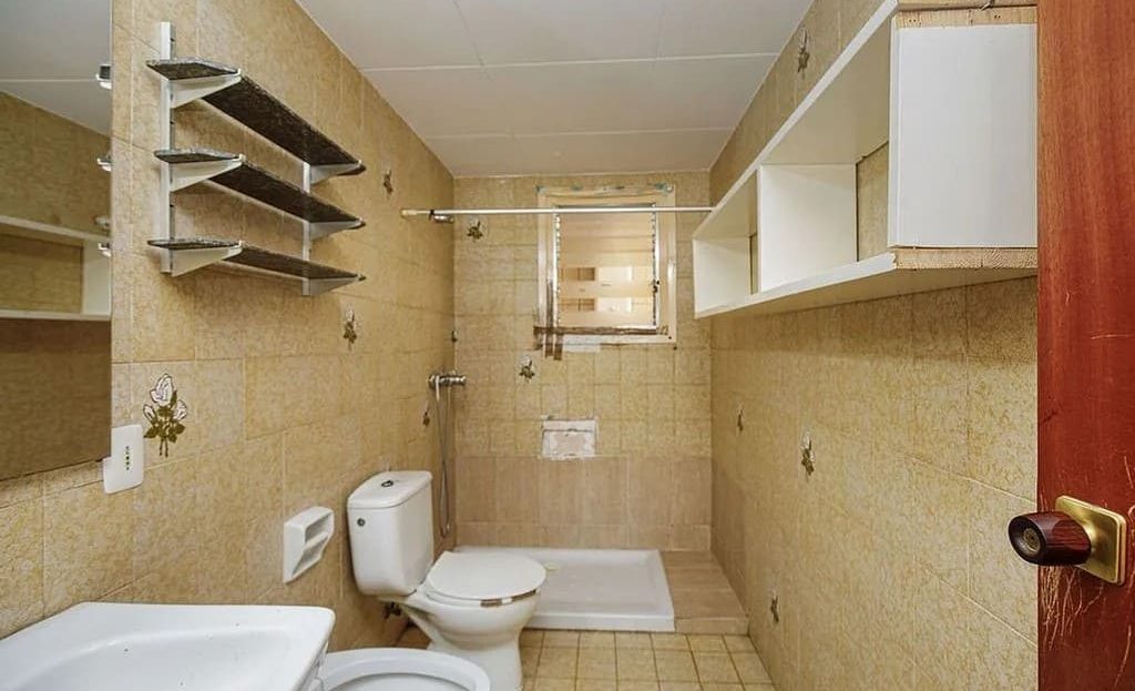 Ванная комната с раковиной, унитазом и встроенными полками