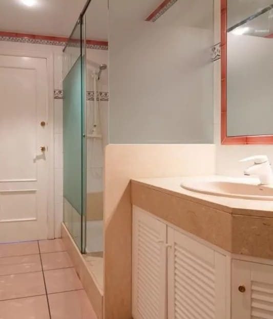 Ванная комната с душевой кабиной и встроенной мебелью.