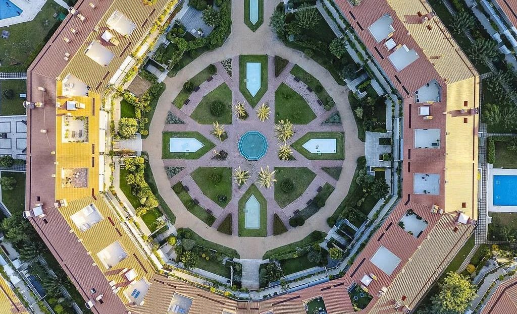 Панорамный вид сверху на элитный жилой комплекс с внутренним двором и бассейнами