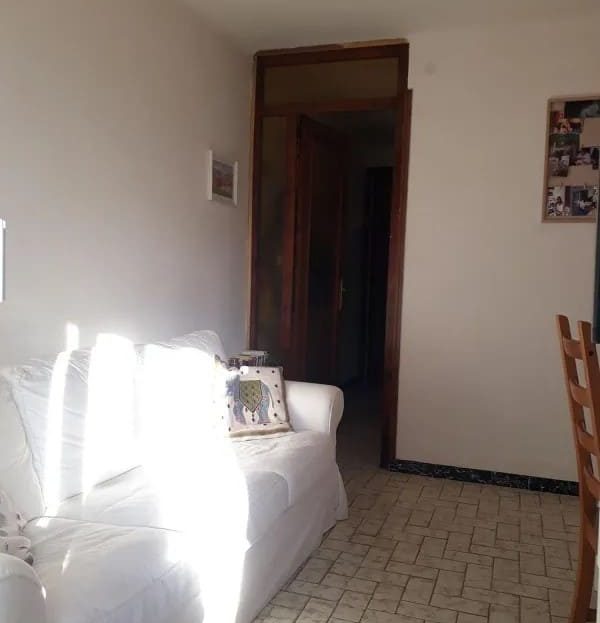 Гостиная с белым диваном и дверью в коридор.