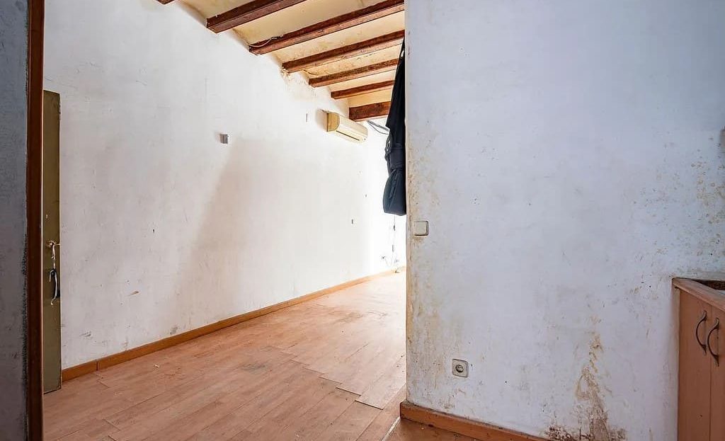 Комната с деревянным полом и стенами под обновление