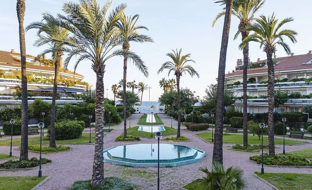 Общий сад с фонтаном и пальмами в охраняемом жилом комплексе