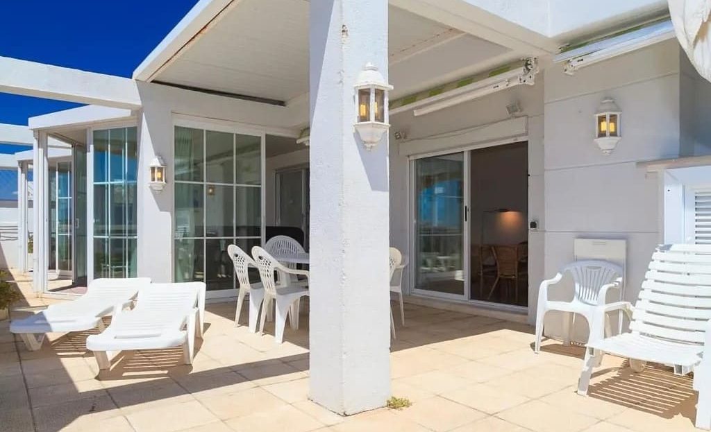 Просторная терраса с навесом и зоной отдыха в пентхаусе.