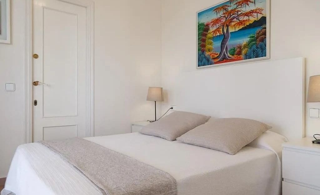 Главная спальня с двуспальной кроватью и светлым интерьером.