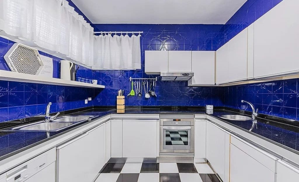 Отдельная кухня с синим фартуком и встроенной техникой