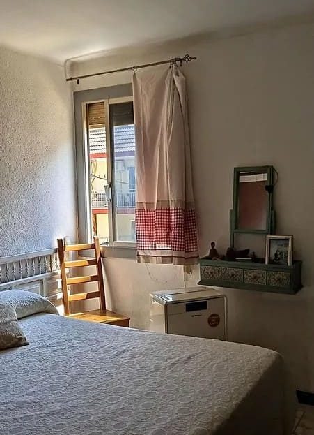 Спальня с кроватью, комодом и окном.