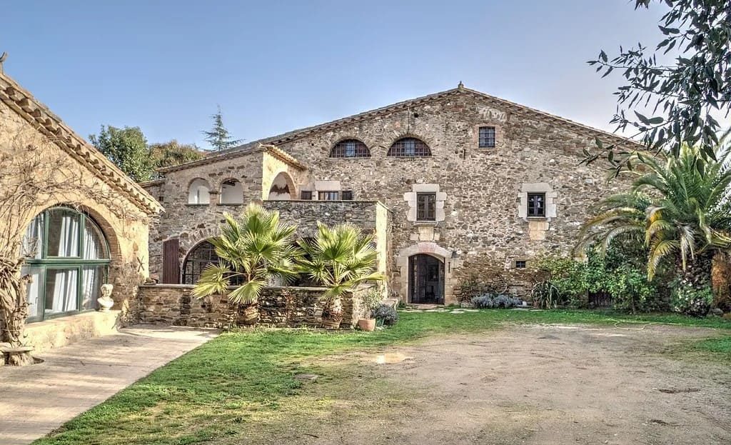 Фасад исторической усадьбы XVII века с каменными стенами и двором