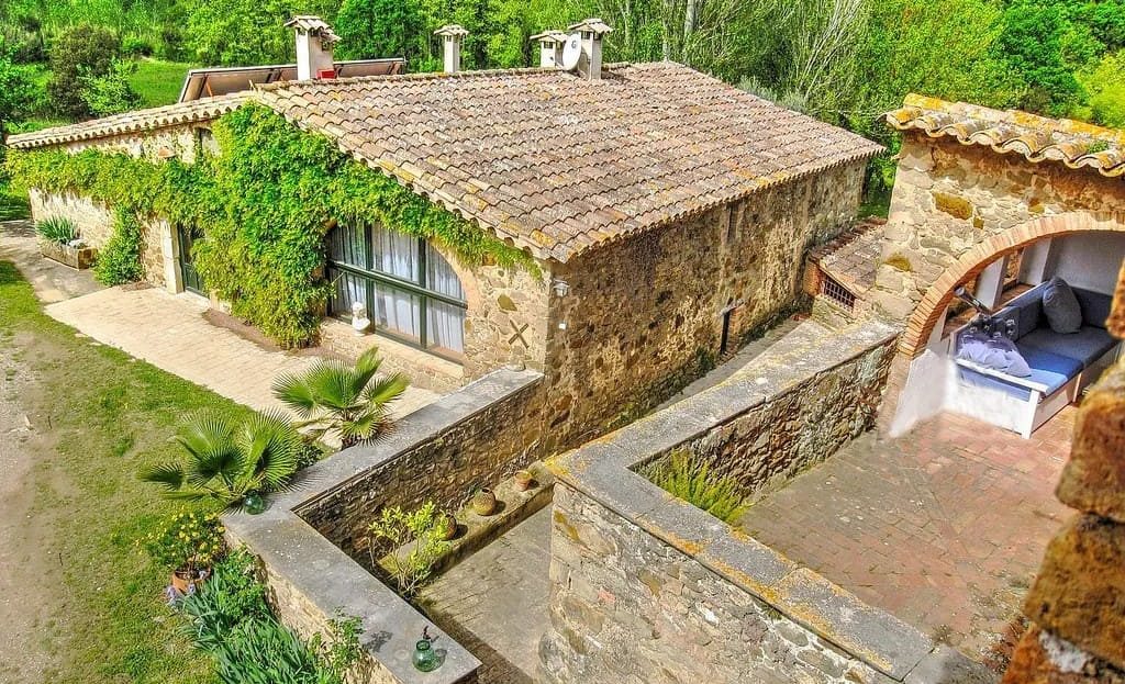 Каменные постройки и террасы усадьбы с традиционной черепичной крышей.