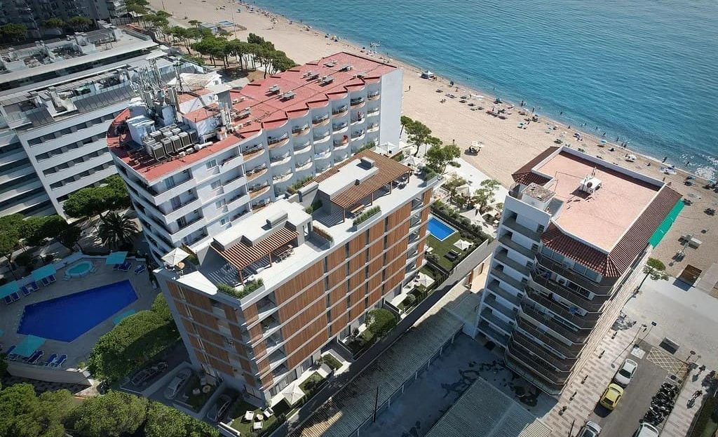 Аэрофото новостройки у пляжа в Плая-де-Аро, вид сверху на здание и набережную