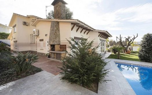 Вид виллы с садом и зоной отдыха возле бассейна