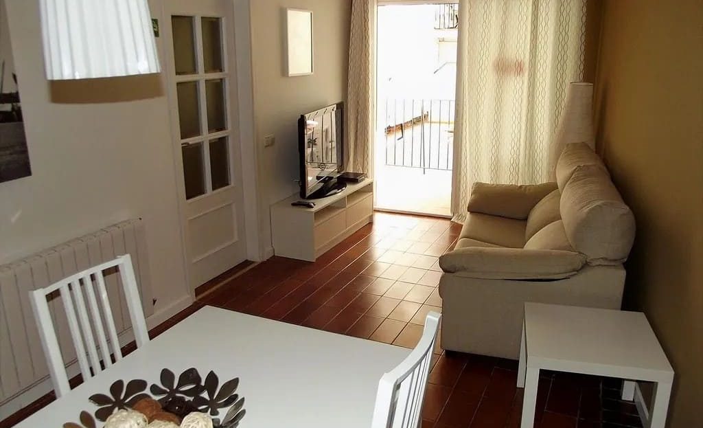 Гостиная с обеденной зоной и выходом на балкон в квартире в центре Ситжеса